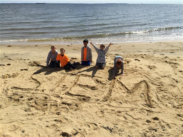 STEM Students working together to create a message in the sand at Phillip Merril in Annapolis, MD
