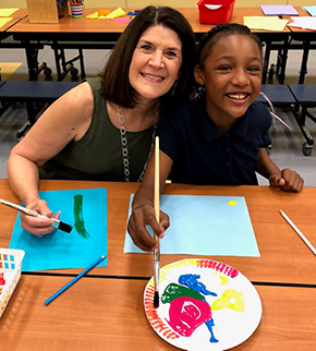 Teacher with student doing art 