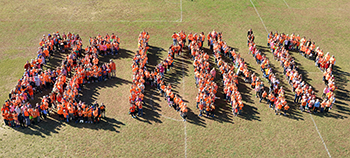 Be Kind formed by students on field 