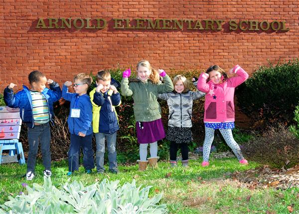 Students under "Arnold Elementary School" sign 