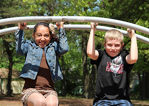 2 kids on bars at playground 