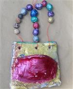 Clay tile with magenta oval and clay beads on a string